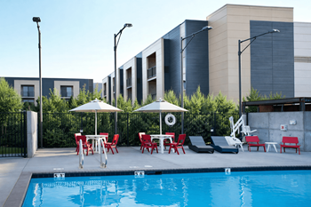 Pool area with seating and modern buildings
